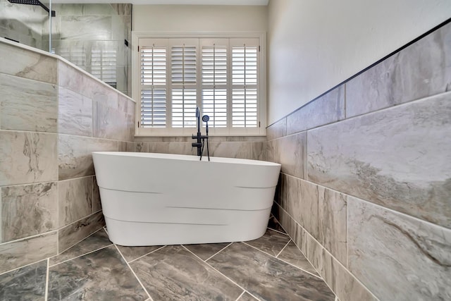 full bathroom with a freestanding tub, marble finish floor, and a walk in shower