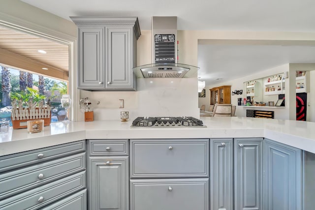 kitchen with range hood, stainless steel gas cooktop, gray cabinets, and light countertops