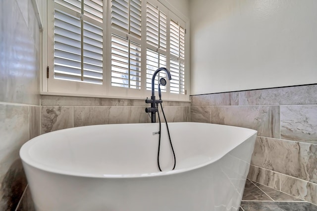 full bathroom with wainscoting and a freestanding tub