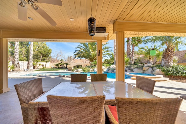 view of patio with outdoor dining space, a fenced backyard, a ceiling fan, and a fenced in pool