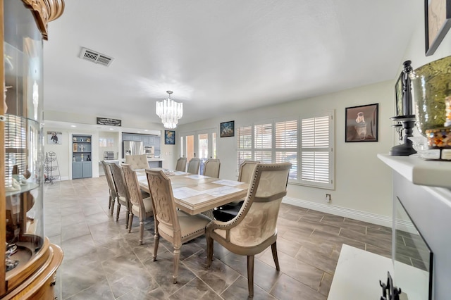 dining area with light tile patterned floors, visible vents, baseboards, and an inviting chandelier