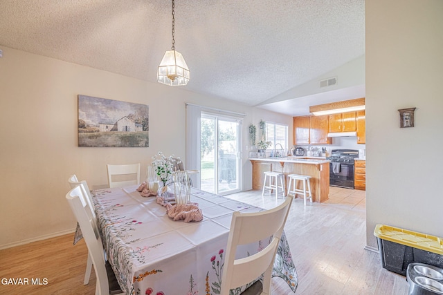37388 Harrow Ct, Palmdale, CA 93550 - dining room with a textured ceiling, light wood finished floors, and lofted ceiling