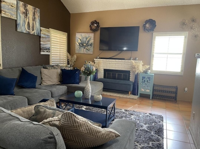 living room featuring tile patterned flooring, a textured ceiling, a fireplace, and lofted ceiling