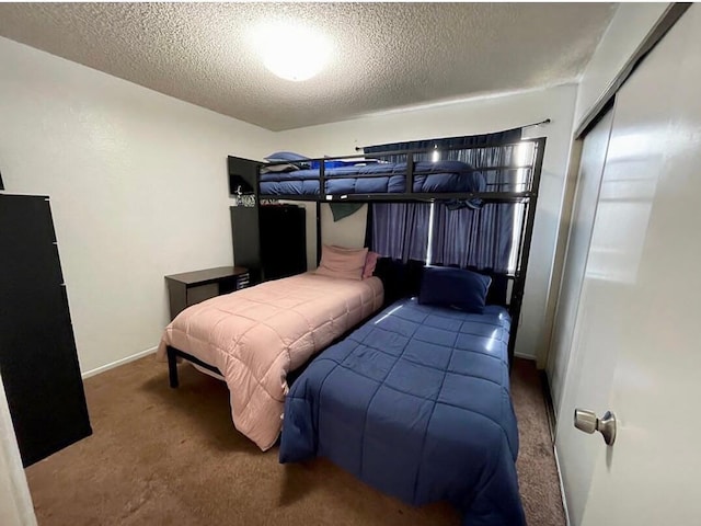 bedroom featuring carpet flooring, a textured ceiling, and a closet