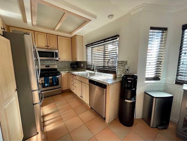 kitchen featuring appliances with stainless steel finishes, light brown cabinetry, sink, plenty of natural light, and light tile patterned flooring