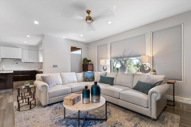 living room featuring ceiling fan, light wood-type flooring, and recessed lighting