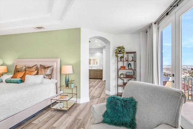 bedroom featuring access to exterior, arched walkways, visible vents, and multiple windows