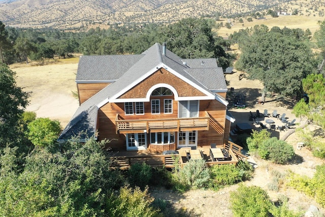 rear view of house with an outdoor living space, a deck, and french doors