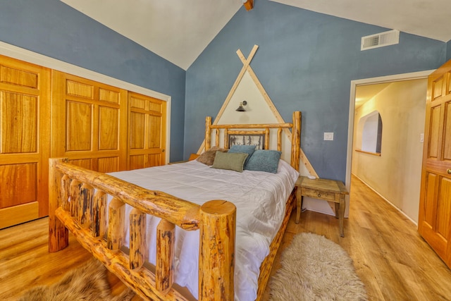 bedroom with light wood-type flooring and vaulted ceiling