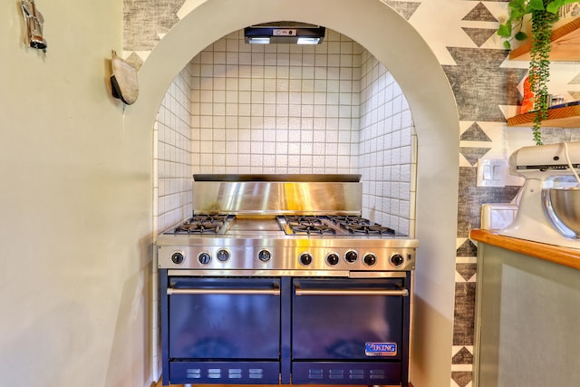 kitchen featuring backsplash and high end range