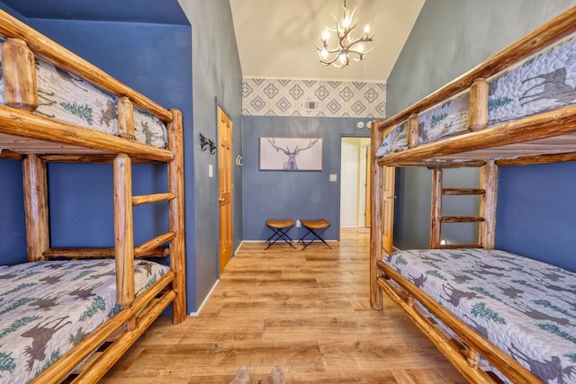 bedroom with light hardwood / wood-style flooring and an inviting chandelier