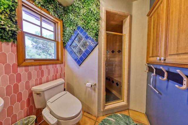 bathroom featuring tile patterned flooring, toilet, and an enclosed shower