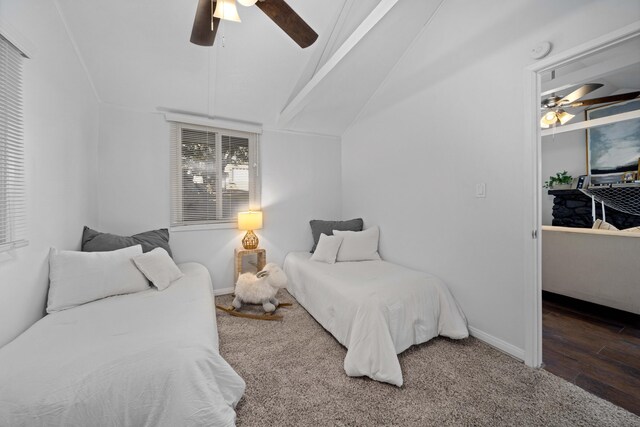 bedroom featuring dark wood-style floors, baseboards, vaulted ceiling, and a ceiling fan