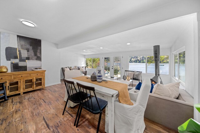 living area with a wealth of natural light, a water view, and wood finished floors