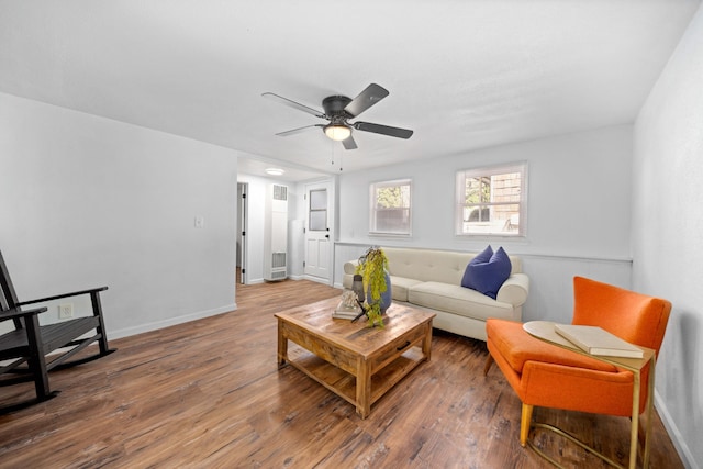 living room featuring wood finished floors, a ceiling fan, and baseboards