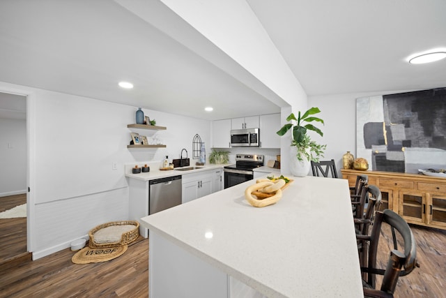 kitchen featuring appliances with stainless steel finishes, light countertops, dark wood-style floors, and white cabinetry