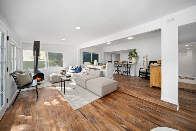 living room with a wood stove, dark wood-style floors, and recessed lighting