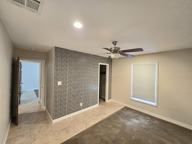 unfurnished bedroom with baseboards, a ceiling fan, and visible vents