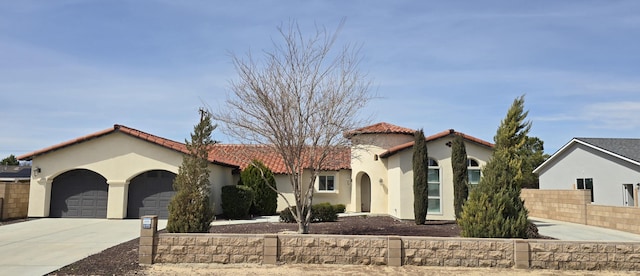 mediterranean / spanish-style house with driveway, a tile roof, a garage, fence, and stucco siding