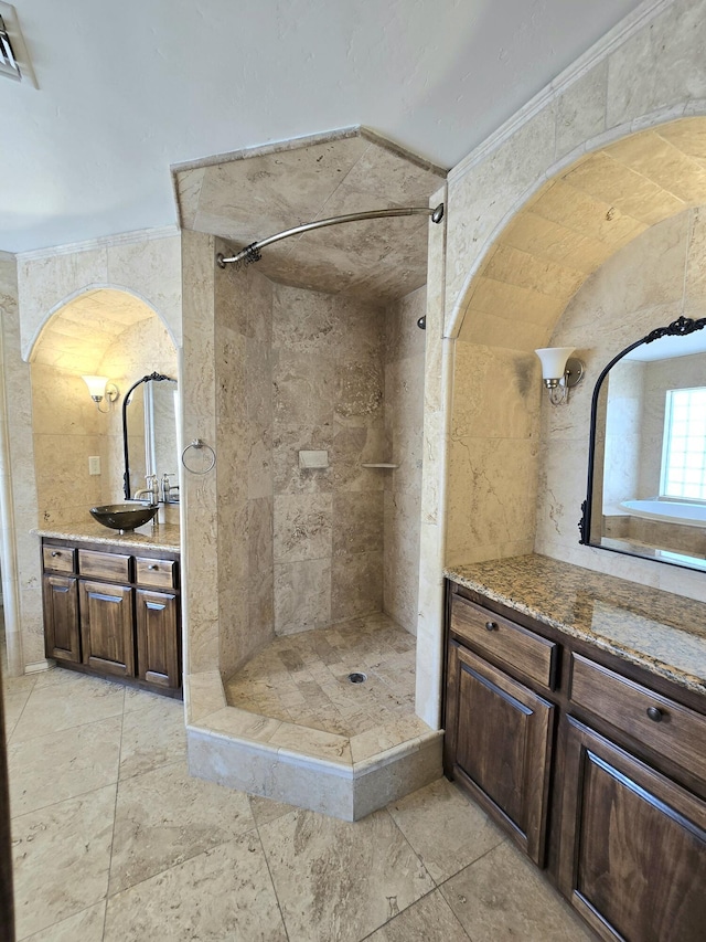 bathroom with tile walls, tiled shower, and vanity