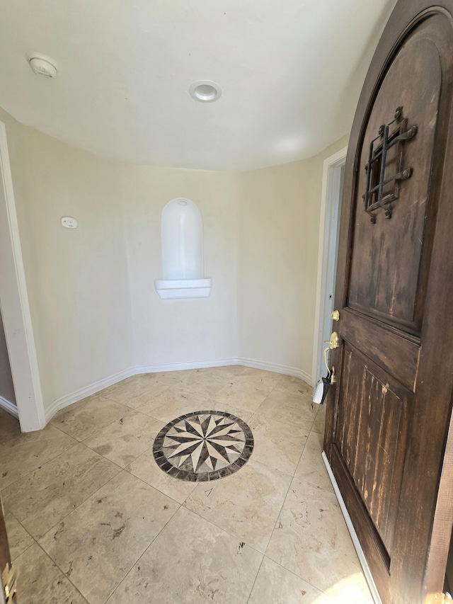 foyer with light tile patterned flooring and baseboards