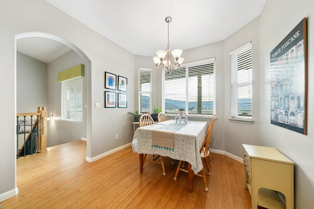 23831 Lakeview Dr, Tehachapi, CA 93561 - dining space featuring arched walkways, a chandelier, light wood-style flooring, and baseboards