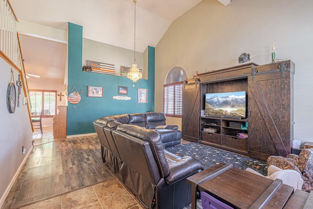 living room with a barn door, lofted ceiling, and a chandelier