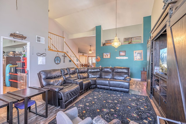 living room with hardwood / wood-style flooring, ceiling fan, and high vaulted ceiling