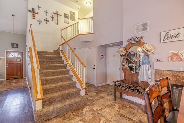 foyer featuring a tiled fireplace and high vaulted ceiling