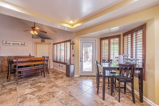 dining area featuring a raised ceiling, ceiling fan, and vaulted ceiling