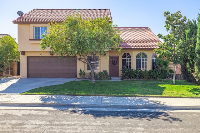 mediterranean / spanish-style house featuring a garage and a front lawn