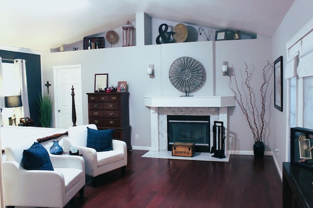 living room with lofted ceiling, a tiled fireplace, and wood-type flooring