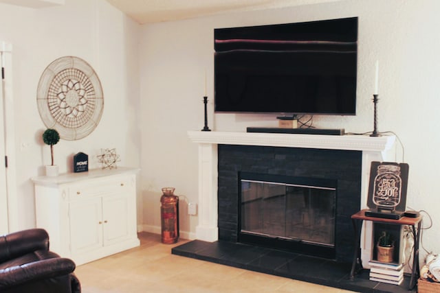 living room with light tile patterned floors and a fireplace