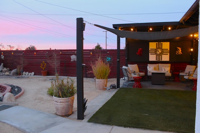 patio terrace at dusk with a fire pit and a yard