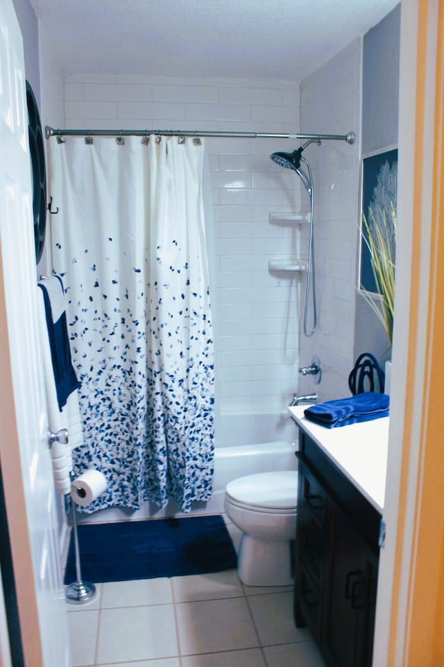 full bathroom featuring toilet, vanity, tile patterned flooring, and shower / bathtub combination with curtain