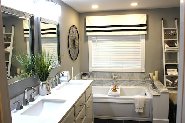 bathroom featuring a bathing tub, tile patterned floors, and vanity