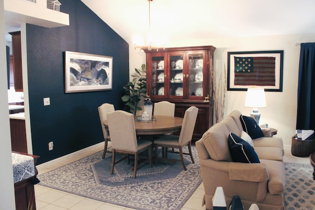 tiled dining room featuring vaulted ceiling