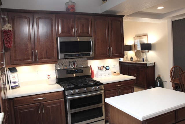 kitchen featuring dark brown cabinets, stainless steel appliances, and a kitchen island