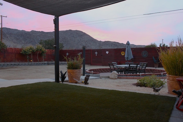 yard at dusk with a patio area and a mountain view