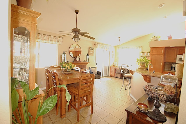 dining space featuring light tile patterned floors, a ceiling fan, and lofted ceiling