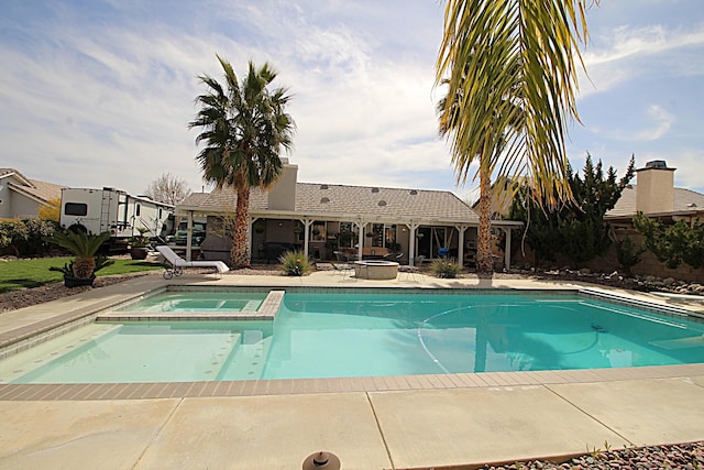 view of swimming pool featuring a pool with connected hot tub and a patio area