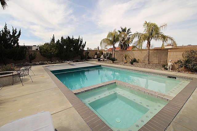 view of pool with a patio, a fenced backyard, and a pool with connected hot tub