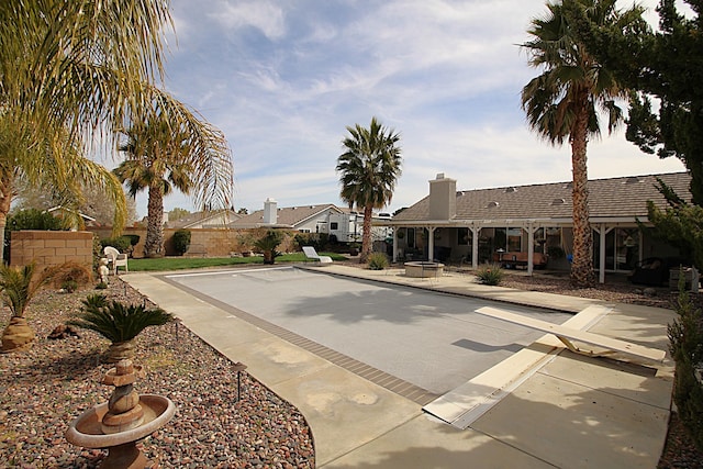 exterior space featuring a patio area, a fenced backyard, and an outdoor fire pit