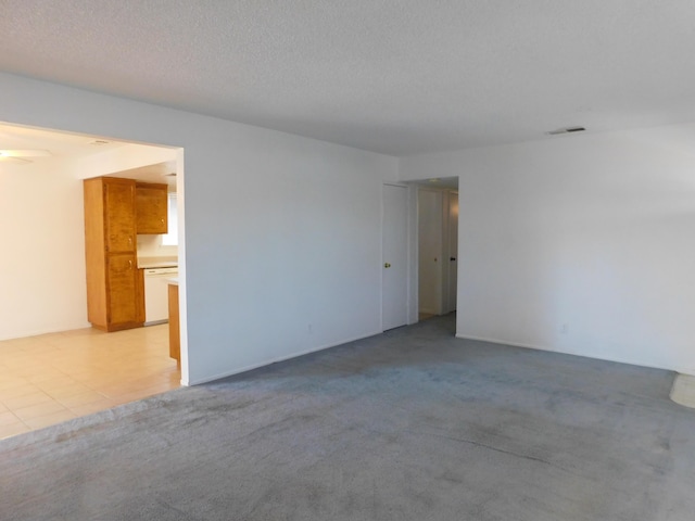 carpeted spare room featuring a textured ceiling