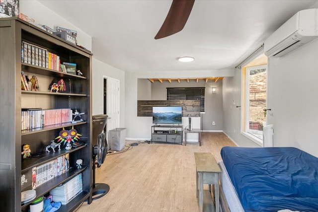 living room with ceiling fan, light wood-type flooring, and a wall mounted AC