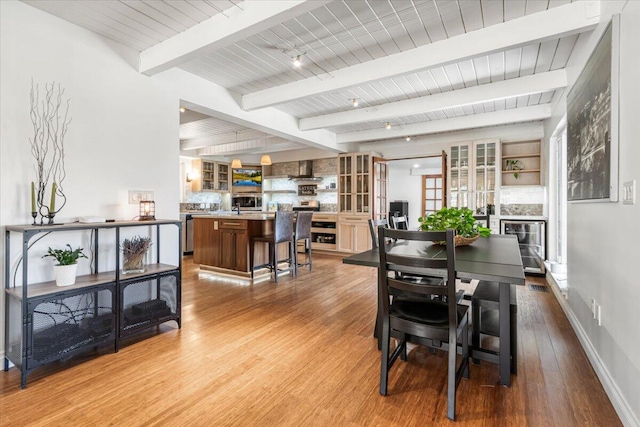 dining space featuring hardwood / wood-style flooring, beamed ceiling, and french doors