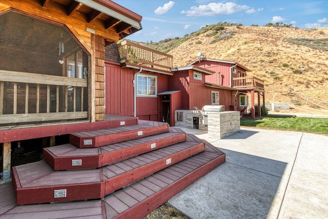 view of patio featuring area for grilling, a mountain view, and a balcony