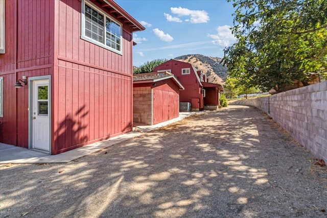 view of property exterior with a mountain view and central AC unit