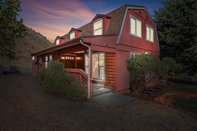 property exterior at dusk featuring covered porch