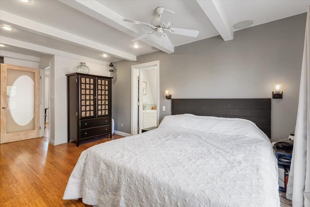 bedroom featuring beamed ceiling, ceiling fan, hardwood / wood-style flooring, and ensuite bath